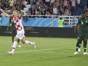 Croatia's Domagoj Vida, left, celebrates after Nigeria's Oghenekaro Etebo, right, scored an own goal during the group D match between Croatia and Nigeria at the 2018 soccer World Cup in the Kaliningrad Stadium in Kaliningrad, Russia, Saturday, June 16, 2018.