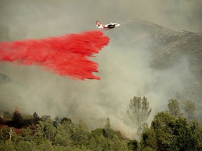 File - In this June 24, 2018 file photo, an air tanker drops retardant on a wildfire burning above the Spring Lakes community near Clearlake Oaks, Calif. Fire crews are gaining ground against the Northern California wildfire that forced more than 1,000 people to flee their homes and has destroyed 12 homes. The California's Department of Forestry and Fire Protection said Wednesday, June 27, 2018, the fire in Lake County north of San Francisco is 25 percent contained as Wednesday morning, up from 17 percent on Tuesday.