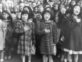 FILE - In this April 1942 file photo made available by the Library of Congress, children at the Weill public school in San Francisco recite the Pledge of Allegiance. Some of them are evacuees of Japanese ancestry who will be housed in War Relocation Authority centers for the duration of World War II. Throughout American history, during times of war and unrest, authorities have cited various reasons and laws to take children away from their parents. Examples include Native American boarding schools, Japanese internment camps and deportations that happened during the Great Depression.