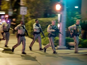 FILE - In this Oct. 1, 2017, file photo, police run toward the scene of a shooting near the Mandalay Bay resort and casino on the Las Vegas Strip in Las Vegas. Police planned to release body-worn camera video from officers who responded to the deadliest shooting in the nation's modern history last year on the Las Vegas Strip. The material released Wednesday, June 13, 2018, represents the sixth batch of Oct. 1 shooting material released since May 30 without comment by Clark County Sheriff Joe Lombardo or his department. Fifty-eight people died and hundreds were injured before authorities say the gunman, Stephen Paddock, killed himself before police reached him.