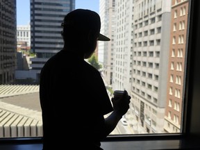 In this photo taken Friday, June 22, 2018, an 18-year-old Honduran who said he suffered abuse inside a Virginia immigration detention facility poses in front of a window in San Francisco. The teen's experience echoes abuse claims by other children whose accounts are included in a federal civil rights lawsuit charging that guards at the Shenandoah Valley Juvenile Center in Staunton, Virginia, beat them, locked them up for long periods in solitary confinement and left them nude and shivering in concrete cells.