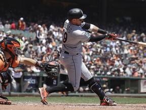 Miami Marlins' Miguel Rojas, right, hits an RBI-single in front of San Francisco Giants catcher Nick Hundley during the second inning of a baseball game in San Francisco, Wednesday, June 20, 2018.