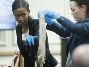 Daniellla Stuart, left, a Georgia Bureau of Investigation special agent and crime scene specialist, with Marie Broder, assistant DA, shows the jury a burned shirt she found in the defendant's well that had cuts consistent with stab wounds during trial Thursday, June 21, 2018, in Griffin, Ga. Testimony is under way in Georgia in the cold-case slaying of a black man whom authorities have said was killed because of racism. Frank Gebhardt is charged with malice murder in the killing of Timothy Coggins near Griffin, Georgia, in 1983. The killing remained unsolved until last fall, when authorities announced the arrests of the 60-year-old Gebhardt and another white man.