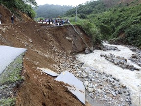 In this Monday, June 25, 2018, photo, part of a road is collapsed by landslides in northern province of Lai Chau, Vietnam. Flash floods and landslides in northern Vietnam caused casualties. Weather forecasters warn of more floods and landslides in the region.