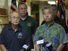 FILE - In this Jan. 13, 2018, file photo, Vern Miyagi, administrator of the Hawaii Emergency Management Agency (HEMA), left, and Hawaii Gov. David Ige listen as they address the media during a news conference at HEMA at Diamond Head in Honolulu, following the false alarm issued of a missile launch on Hawaii. An employee of the Hawaii agency that mistakenly sent cellphone and broadcast alerts warning of a missile attack in January says he saw staff members watching movies or TV on the job.