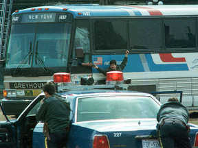 RCMP officers keep watch on a hijacked bus on Parliament Hill as a two-way radio is being handed to the driver, April 7, 1989.