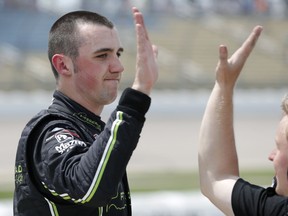 Austin Cindric celebrates with a crew member after winning the pole position for a NASCAR Xfinity Series auto race, Sunday, June 17, 2018, at Iowa Speedway in Newton, Iowa.