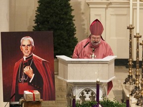 FILE - In this Dec. 11, 2011 file photo, Peoria Bishop Daniel Jenky, center, gives a sermon next to a painting of Archbishop Fulton John Sheen and the sealed box of documentation for the alleged miracle performed by Sheen, during a Mass at Cathedral of St. Mary of the Immaculate Conception in Peoria, Ill. The remains of Sheen, who died in 1979 and are at St. Patrick's Cathedral in Manhattan, can be moved to Illinois from New York, nearly 40 years after his death, a New York judge said Friday, June 8, 2018. Joan Sheen Cunningham, 90, believes moving her uncle's remains to Peoria, will improve his cause for sainthood.