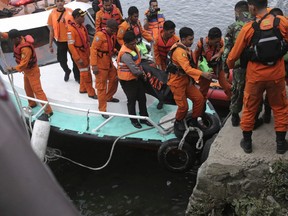 Indonesian search and rescue team carry a victim body of a ferry sinking at Tigaras port in Toba lake, North Sumatra, Wednesday, June, 20, 2018.