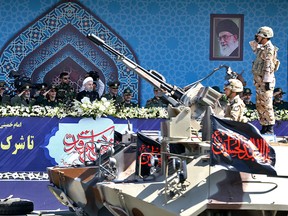 Iranian President Hassan Rouhani reviews a military parade in front of the shrine of Iran's late revolutionary founder, Ayatollah Khomeini, outside Tehran on Sept. 22, 2017.