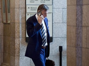 Conservative MP Maxime Bernier talks on his phone as he leaves a caucus meeting on Parliament Hill in Ottawa on Wednesday, June 13, 2018.