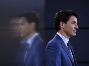 Prime Minister Justin Trudeau is reflected in a TV screen as he speaks at a press conference in Ottawa on Wednesday, June 20, 2018.