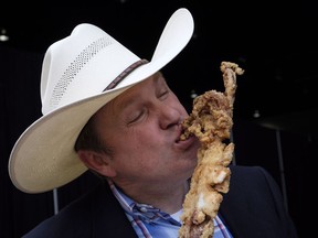 James Radke, midway operations manager at the Calgary Stampede, samples a deep fried giant squid that will be available at this year's Stampede in Calgary, Tuesday, June 5, 2018.