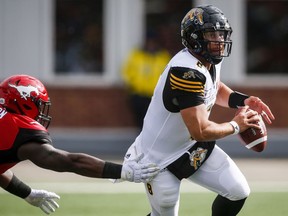 Hamilton Tiger-Cats quarterback Jeremiah Masoli, right, escapes from Calgary Stampeders' Micah Johnson during first half CFL football action in Calgary, Saturday, June 16, 2018.THE CANADIAN PRESS/Jeff McIntosh