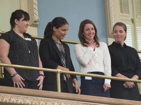 Former national ski team members Emilie Cousineau, from the left, Anna Prchal, Gail Kelly and Genevieve Simard stand as they are applauded for their courage after a motion by the National Assembly, Tuesday, June 12, 2018 at the legislature in Quebec City.