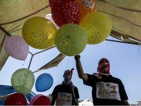 Palestinian protesters prepare kites loaded with flammable material to be flown towards Israel, at the Israel-Gaza border in al-Bureij, central Gaza Strip on June 14, 2018.