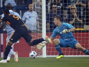 Houston Dynamo forward Mauro Manotas (9) scores past Sporting Kansas City goalkeeper Tim Melia, right, during the first half of an MLS soccer match in Kansas City, Kan., Saturday, June 23, 2018.