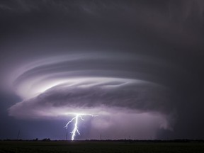 A lightning bolt emerges from a severe thunderstorm just west of Wichita, Kan., on Tuesday, June, 26, 2018. Multiple storms erupted over south-central Kansas on Tuesday.