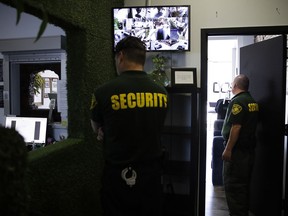 FILE - In this June 27, 2017 photo, two security guards stand watch at a medical marijuana dispensary in Los Angeles, a business conducted mostly in cash. The legal marijuana industry often finds the doors locked at banks, its money unwanted because the drug remains illegal under federal law. But President Donald Trump might help change that, at least partly. The Republican president last week said he was inclined to support a bipartisan proposal in Congress to ease the U.S. ban on marijuana, which if enacted could encourage more banks to accept money from cannabis companies.