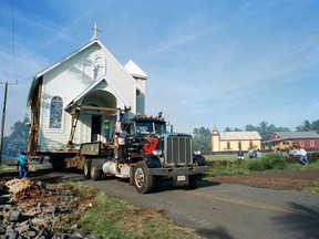FILE - This May 4, 1990 file photo shows the Star of the Sea Church being transported to a safer location as lava continues to flow into Kalapana, Hawaii. Kilauea has destroyed more than 600 homes since it began spraying lava out of a vent on a residential street on May 3, 2018. The newly homeless aren't alone: over the past century Kilauea has covered large parts of the Big Island multiple times.