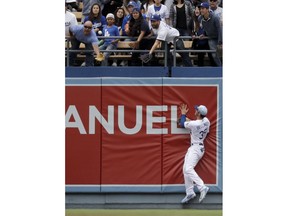 Fans try to catch a two-run home run ball hit by San Francisco Giants' Brandon Belt as Los Angeles Dodgers first baseman Cody Bellinger looks on during the third inning of a baseball game in Los Angeles, Sunday, June 17, 2018.