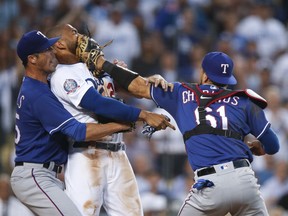 Texas Rangers starting pitcher Cole Hamels, left, restrains Los Angeles Dodgers' Matt Kemp as Kemp scuffles with Rangers catcher Robinson Chirinos during the third inning of a baseball game Wednesday, June 13, 2018, in Los Angeles.