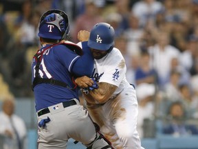 Los Angeles Dodgers' Matt Kemp, right, shoves Texas Rangers catcher Robinson Chirinos while trying to score on a single hit by Enrique Hernandez during the third inning of a baseball game Wednesday, June 13, 2018, in Los Angeles.