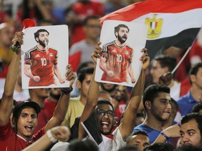 FILE - In this file photo from June 9, 2018, Egypt fans hold poster of striker Mohammed Salah during the team's final training session in Cairo before the World Cup.