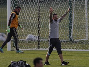 FILE - In this June 12, 2018 file photo, Colombian singer Maluma, right, gestures next to Mexico goalkeeper Jose de Jesus Corona, left, at the end of a training session of the Mexico national soccer team at the World Cup in Moscow. Russian police say that $800,000 worth of valuables have been stolen from Maluma's hotel room in Moscow while he's visiting Russia to support the Colombia team at the World Cup.