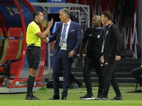 FILE - In this file photo from June 20, 2018, Iran head coach Carlos Queiroz, second left, talks to an assistant referee during the Group B match between Iran and Spain at the World Cup in Kazan, Russia, Spain won 1-0.