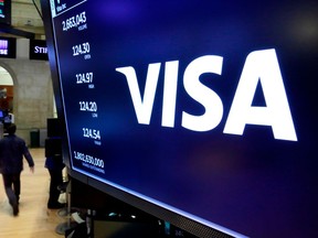 FILE- In this April 23, 2018, file photo, the logo for Visa appears above a trading post on the floor of the New York Stock Exchange. Visa says a problem that left people across Europe unable to use their cards was caused by a hardware fault, not a cyberattack. The card payments company says services are back to normal and its systems are working at "full capacity." It says the problem was caused by "a hardware failure within one of our European systems" and wasn't the result of "unauthorized access."