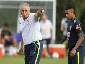 Brazil coach Tite, left, is flanked by Jesus as he leads a training session ahead of Sunday's friendly soccer match against Croatia, at the Enfield Training center, in London Thursday, May 31, 2018.