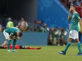 Germany's Thomas Mueller, right, wipes his face after his team lose the group F match between South Korea and Germany, at the 2018 soccer World Cup in the Kazan Arena in Kazan, Russia, Wednesday, June 27, 2018. South Korea won the match 2-0.