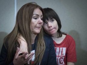 FILE - In this June 11, 2018 file photo, Billy Caldwell sits with his mother Charlotte. Former British Foreign Secretary William Hague called Tuesday, June 19 for the government to take steps toward legalizing marijuana. Hague changed his public stance on cannabis policy days after the government relented and allowed a 12-year-old epileptic boy to receive cannabis oil treatment that his mother said was needed to prevent life-threatening seizures. Home Secretary Sajid Javid said he was convinced after talking to clinicians that the boy, Billy Caldwell, faced a medical crisis.