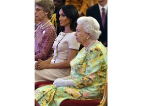 Britain's Queen Elizabeth and Meghan, Duchess of Sussex attend the Queen's Young Leaders Awards ceremony at Buckingham Palace in London, Tuesday, June 26, 2018.