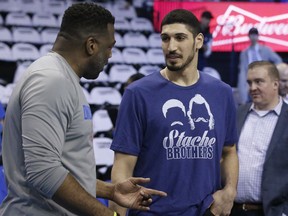 FILE - In this Wednesday, April 25, 2018 file photo, New York Knicks' Enes Kanter, right, a former Oklahoma City Thunder center, talks with Mark Bryant, left, a Thunder assistant coach, before Game 5 of an NBA basketball first-round playoff series between the Utah Jazz and the Thunder in Oklahoma City. Turkey's official news agency says a court has accepted an indictment charging the father of NBA player Enes Kanter with "membership in a terror group." Anadolu Agency said Monday, June 18 that an investigation of Mehmet Kanter was completed and prosecutors would seek a conviction and a prison term of five to 10 years at trial. Enes Kanter, who plays for the New York Knicks, is a follower of a U.S.-based Turkish cleric who the government accuses of masterminding a 2016 failed coup.