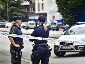 Police stand next to a cordon in central Malmo, southern Sweden, Monday, June 18, 2018.