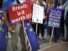 In this photo taken Wednesday, June 20, 2018, anti-Brexit, pro-EU supporters hold placards during a protest near the Houses of Parliament in London. The divisions opened up by the 2016 referendum have not healed, but hardened, splitting Britain into two camps: leavers and remainers. Almost the only thing the two groups share is pessimism about the way Brexit is going.