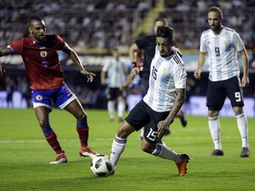FILE - In this Tuesday, May 29, 2018 file photo, Argentina's Manuel Lanzini controls the ball as Haiti's Fabien Vorbe, left, watches during a friendly soccer match in Buenos Aires, Argentina. Argentina says midfielder Manuel Lanzini has torn a ligament in his right knee, ruling him out of the World Cup. Argentina says that Lanzini injured his leg while the team trained in Barcelona, Spain on Friday, June 8, 2018.