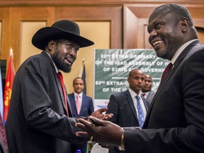 FILE - In this file photo dated Thursday, June 21, 2018, South Sudan's President Salva Kiir, left, and opposition leader Riek Machar, right, shake hands during peace talks in Addis Ababa, Ethiopia.  Competing claims of troops violating the country's latest cease-fire seem to indicate a shaky start to the latest attempt at ending South Sudan's devastating five-year civil war.