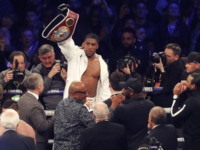 FILE- In this file photo dated Saturday, March 31, 2018, Britain's Anthony Joshua celebrates after his WBA, IBF, WBO and IBO Heavyweight Championship title bout against New Zealand's Joseph Parker in Cardiff, Wales.  Joshua was given a 24-hour deadline on Tuesday june 26, 2018, to sign a deal to fight Russian contender Alexander Povetkin or face being stripped of the WBA portion of his world heavyweight boxing titles.
