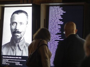 FILE  - In this Friday, Oct. 30, 2015 file photo, visitors look at an exposition at the opening of the Gulag history museum in Moscow, Russia. A museum studying the history of Soviet prison camps said Friday, June 8, 2018 that it has discovered a recent, secret Russian order instructing officials to destroy data on prisoners. Up to 17 million people were sent to the Gulag, the notorious Soviet prison camp system, in the 1930s and 1940s, and at least 5 million of them were convicted on false testimony. The prison population in the sprawling labor camps peaked at 2 million people.