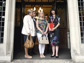 Northern Ireland campaigner for Amnesty International Grainne Teggart, right and  campaigner Sarah Ewart, centre, stand outside the Supreme Court, in Westminster where UK's highest court is to rule on Northern Ireland abortion law challenge, in London, Thursday June 7, 2018. Britain's Supreme Court has criticized Northern Ireland's strict anti-abortion laws but dismissed a legal challenge based on the assertion that the laws are a violation of human rights.