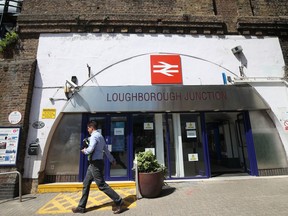 A man walks past Loughborough Junction railway station in south London, Monday June 18, 2018. British Transport Police say three people have died after being struck by a train in south London. Details about the deaths are not yet clear.