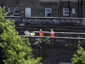 Police officers on a railway track near Loughborough Junction railway station, in south London, Monday June 18, 2018. British Transport Police say three people have died after being struck by a train in south London. Details about the deaths are not yet clear.