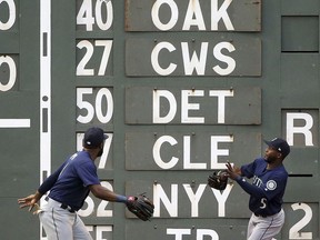 Seattle Mariners left fielder Denard Span, left, fields a double off the wall by Boston Red Sox's J.D. Martinez, as center fielder Guillermo Heredia (5) also chases the ball during the second inning of a baseball game at Fenway Park, Friday, June 22, 2018, in Boston.