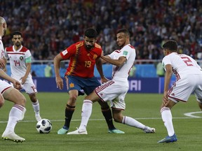 Spain's Diego Costa, center, and Morocco's Romain Saiss challenge for the ball during the group B match between Spain and Morocco at the 2018 soccer World Cup at the Kaliningrad Stadium in Kaliningrad, Russia, Monday, June 25, 2018.