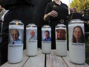 Photos of five journalists adorn candles during a vigil across the street from where they  were slain in their newsroom in Annapolis, Md., Friday, June 29, 2018. Prosecutors say Jarrod W. Ramos opened fire Thursday in the Capital Gazette newsroom.