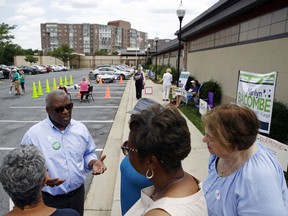 Maryland Democratic gubernatorial candidate Rushern Baker, bottom left, chats with voters outside of a polling place, Tuesday, June 26, 2018, in Silver Spring, Md. Baker and former NAACP President Ben Jealous lead a crowded Democratic primary field to win a nomination to face popular Republican Gov. Larry Hogan in the fall.