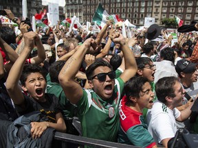 Fans celebrate Mexico's win during the Mexico vs. Germany World Cup soccer match, as they watched it on an outdoor screen in Mexico City's Zocalo, Sunday, June 17, 2018.